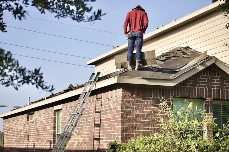 Professional roofer working on a residential roof in Preakness